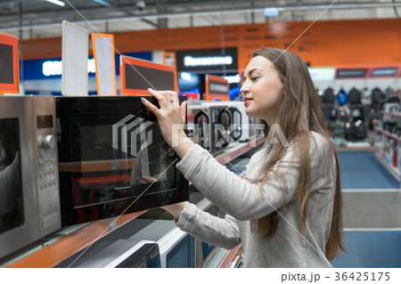 customer girl chooses a microwave oven in a home 36425175