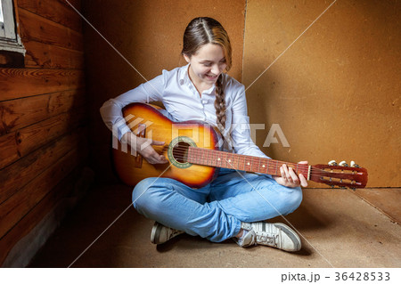 young woman playing guitar 36428533