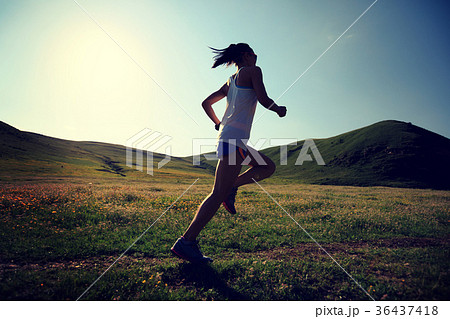 fitness woman runner running on grassland trail 36437418