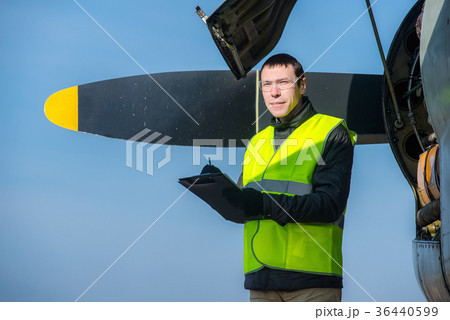 Mechanic checking airplane's engine 36440599
