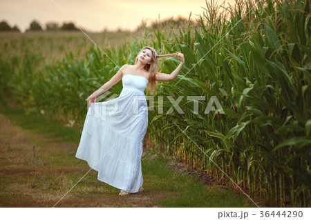 Woman in white dress in a field. 36444290