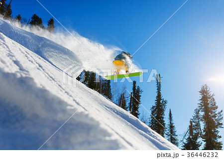 Snowboarder at jump inhigh mountains at sunny day. 36446232