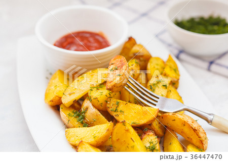 Baked potato slices with herbs in a white dish Baked potato slices with herbs in a white dish 36447470