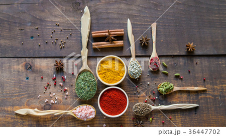 Various colorful herbs and spices on wooden table Various colorful herbs and spices on wooden table 36447702