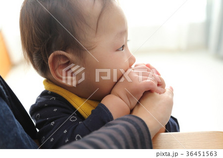 指しゃぶり(ママの手を持って)をする赤ちゃん 指しゃぶり(ママの手を持って)をする赤ちゃん 36451563