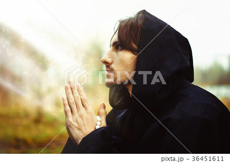 a monk in robes praying in the woods 36451611