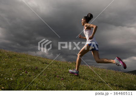 woman runner running up on mountain grassland woman runner running up on mountain grassland 36460511