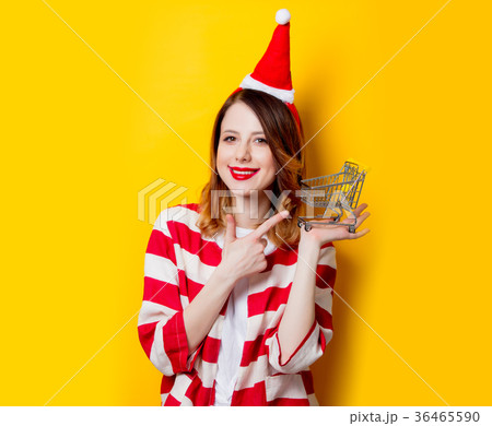woman in Santa Claus hat with supermarket cart 36465590