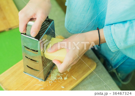 Close-up of a woman's hands rub the parmesan 36467324
