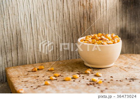 Corn grain in wooden bowl on wooden tray 36473024