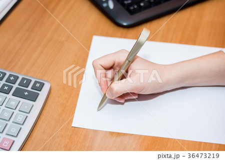 Close up hand with pen writes on paper on desk Close up hand with pen writes on paper on desk 36473219