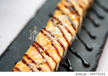 Freshly cooked uncut sushi roll on black board 36473291