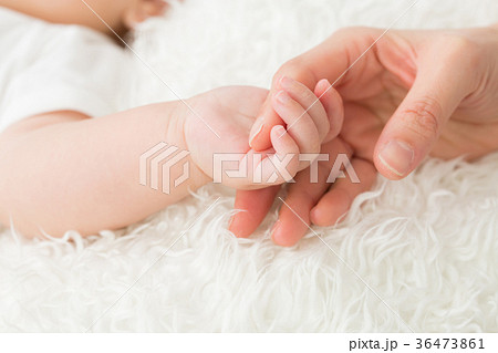 赤ちゃんと手をつなぐ女性の写真素材