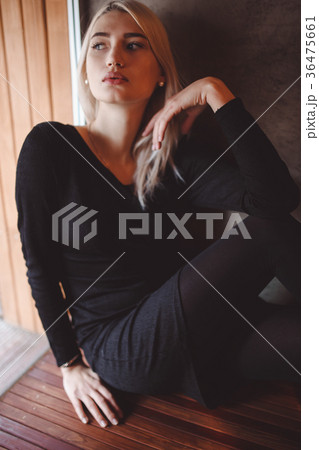 Girl in black casual dress posing near window in 36475661