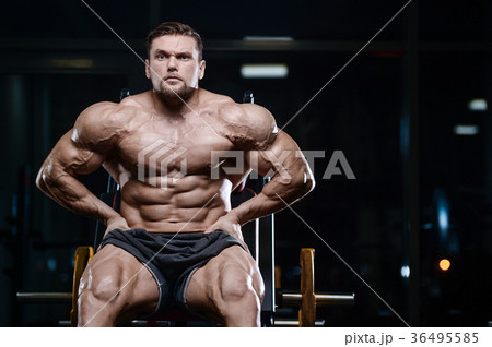 Brutal strong bodybuilder athletic men pumping up muscles with d 36495585