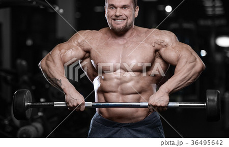 Brutal strong bodybuilder athletic men pumping up muscles with d 36495642
