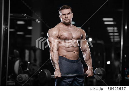 Brutal strong bodybuilder athletic men pumping up muscles with d 36495657