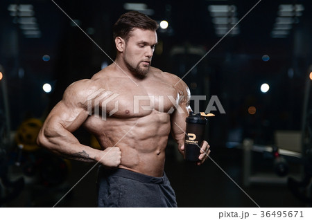 Brutal strong bodybuilder athletic men pumping up muscles with d 36495671