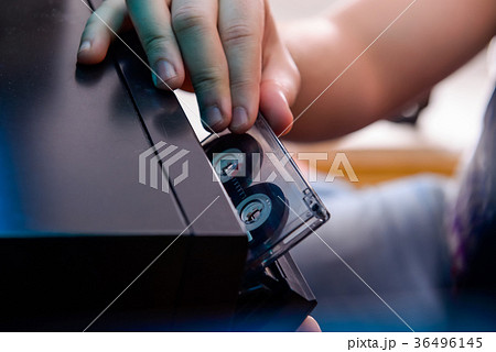 man put CD cassette into old cd audio player. man put CD cassette into old cd audio player. 36496145