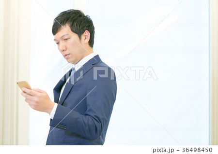 スマホを操作するビジネスマン　携帯電話　スマートフォン　中堅社員　ビジネスイメージ 36498450