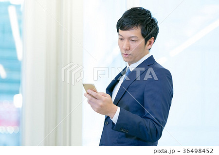 スマホを操作するビジネスマン　携帯電話　スマートフォン　中堅社員　ビジネスイメージ 36498452
