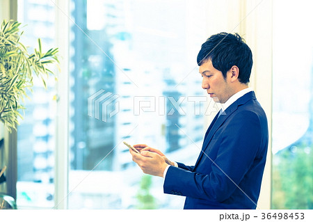 スマホを操作するビジネスマン　携帯電話　スマートフォン　中堅社員　ビジネスイメージ 36498453