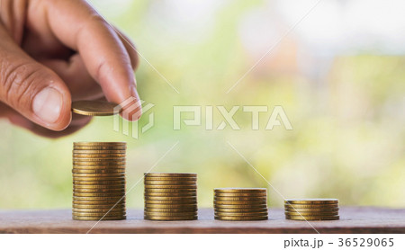 hand putting coins on stack for saving money  36529065