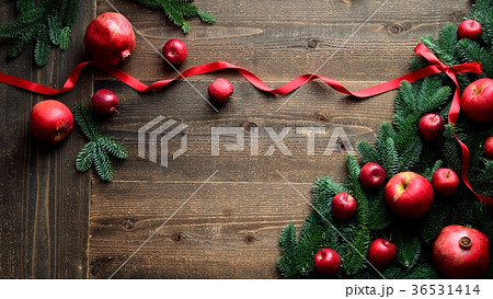 ざくろと林檎のクリスマスツリー 黒木材背景の写真素材