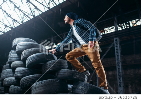 Stalker, traveler climbs a mountain of tires Stalker, traveler climbs a mountain of tires 36535728