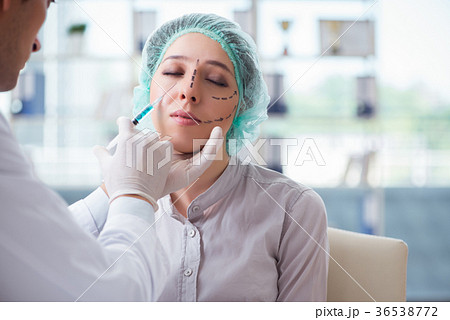 Plastic surgeon preparing for operation on woman 36538772