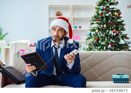 Businessman working at home during christmas Businessman working at home during christmas 36539673