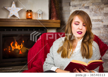 Woman with a book by the fireplace Woman with a book by the fireplace 36540313