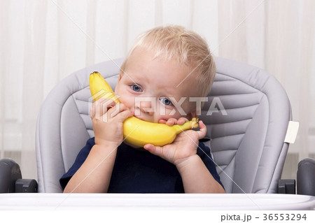 Cute one year old toddler eating a banana and Cute one year old toddler eating a banana and 36553294