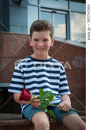 boy holding a rose and smiling. the concept of 36554364