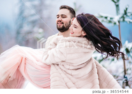 young couple on a walk in the snowy mountains young couple on a walk in the snowy mountains 36554544