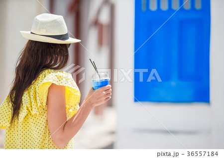 Young woman with coffee to go in narrow streets of Young woman with coffee to go in narrow streets of 36557184