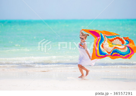 Happy little girl having fun running with pareo on 36557291