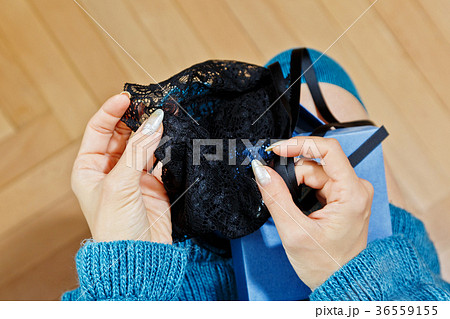 Young woman unpacking presented lingerie 36559155