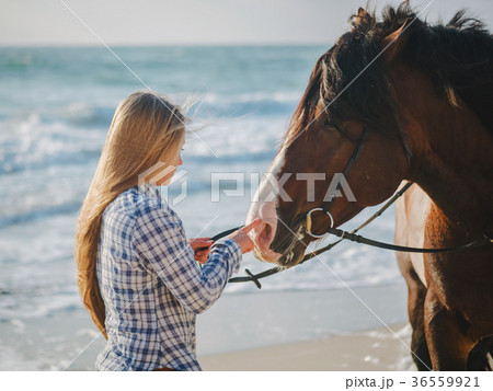 Beautiful fair-haired girl in armor with a horse Beautiful fair-haired girl in armor with a horse 36559921