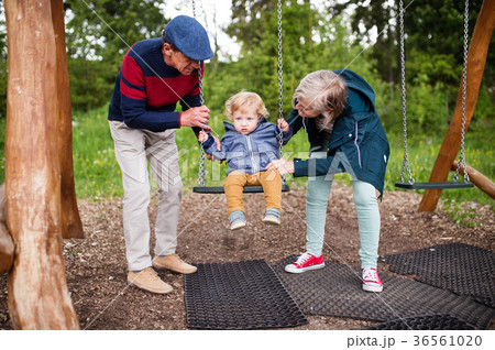 Senior couple with little boy at the playground. 36561020
