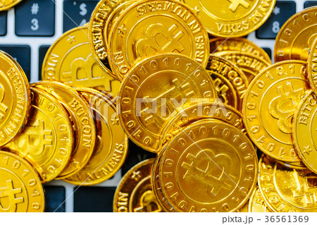 Pile of gold bitcoins on top of a laptop Pile of gold bitcoins on top of a laptop 36561369