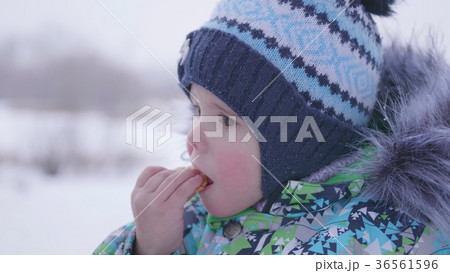 the child eats cookies winter outdoor 36561596
