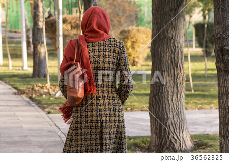 Backside of a Muslim woman walking in a park Backside of a Muslim woman walking in a park 36562325