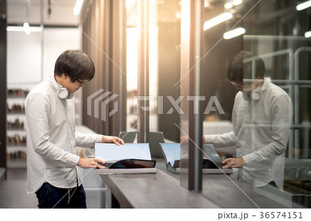Young Asian man student opening book in library 36574151