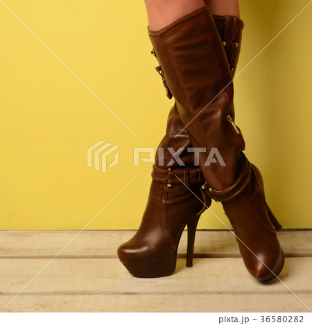 girl in brown spring boots stands cross-legged girl in brown spring boots stands cross-legged 36580282