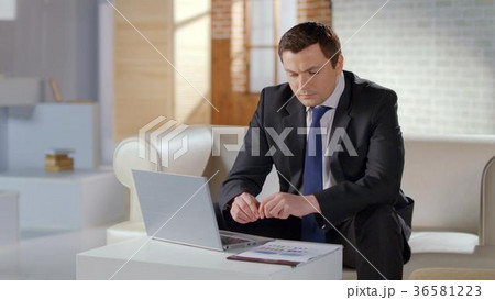 Serious businessman preparing company presentation Serious businessman preparing company presentation 36581223