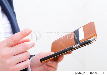 オフィスで携帯を触る女性の手元　コピースペース　スマホ　スマートフォン　携帯電話　白背景 36583354