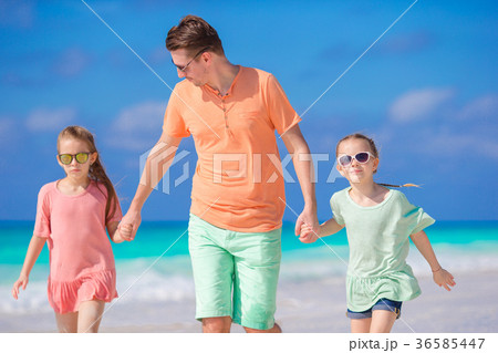 Family of dad and kids walking on white tropical 36585447