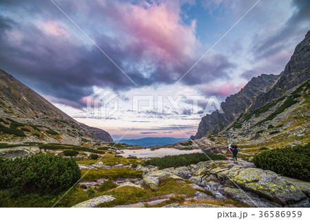 Tourist Takes Picture of Mountain Landscape with a Tarn 36586959