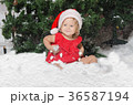 smiling girl in santa costume sits on snow 36587194